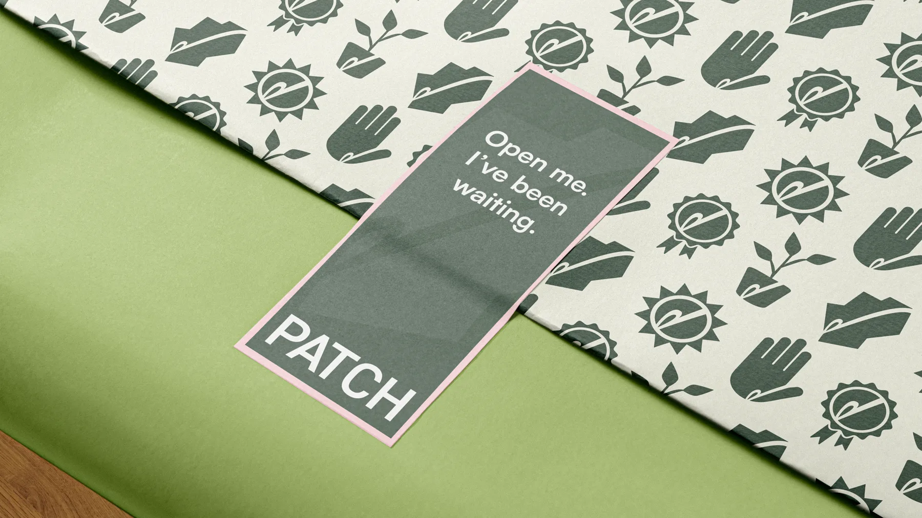 Icon-patterned tissue paper with a sage sticker reading Open me, I have been waiting