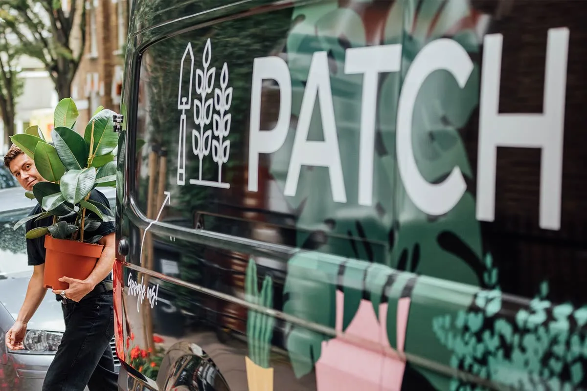 A Patch team member delivering a plant beside a Patch van